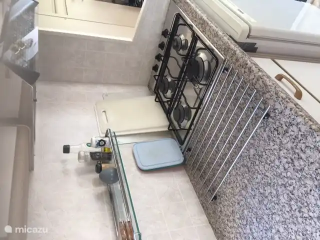 Cocina a gas de 4 fuegos con campana extractora.