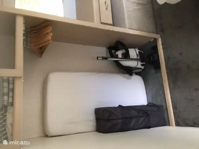 Cama infantil/de camping con colchón. Se quitaron las puertas de los armarios (se pueden cerrar con una cortina) para que la cuna también quepa en el dormitorio.