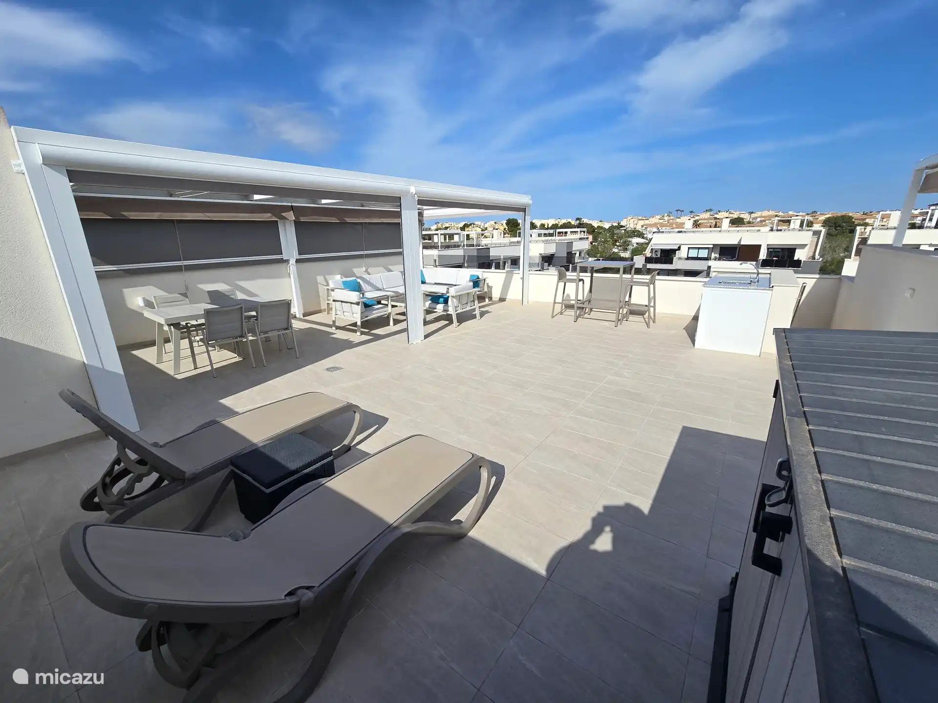 Dakterras met loungeset, eettafel voor 6  personen, hoge sta tafel met 4 krukken en 2 ligstoelen. Tevens een buitenkeuken met koelkastje voor drank en wasbak met water. 