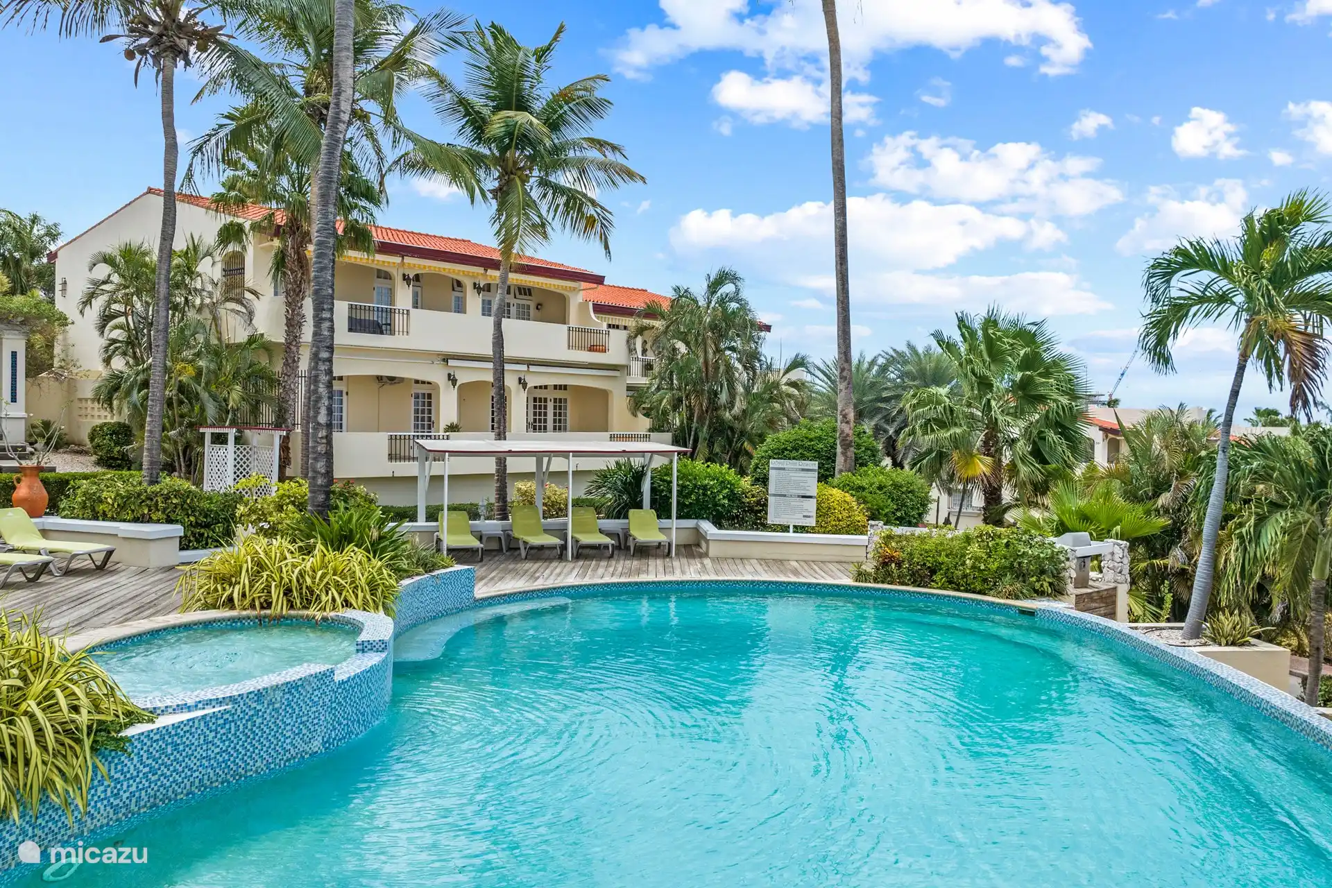 Autour de la piscine partagée, il y a des transats prêts à se détendre au soleil