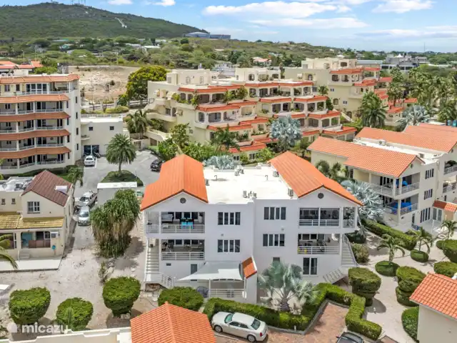 Maison Madeleine | Curaçao, Curaçao-Centre, Piscadera - appartement Cette photo d’ensemble montre la terrasse confortable, avec les chaises bleues caractéristiques de l’appartement - un endroit agréable pour se détendre