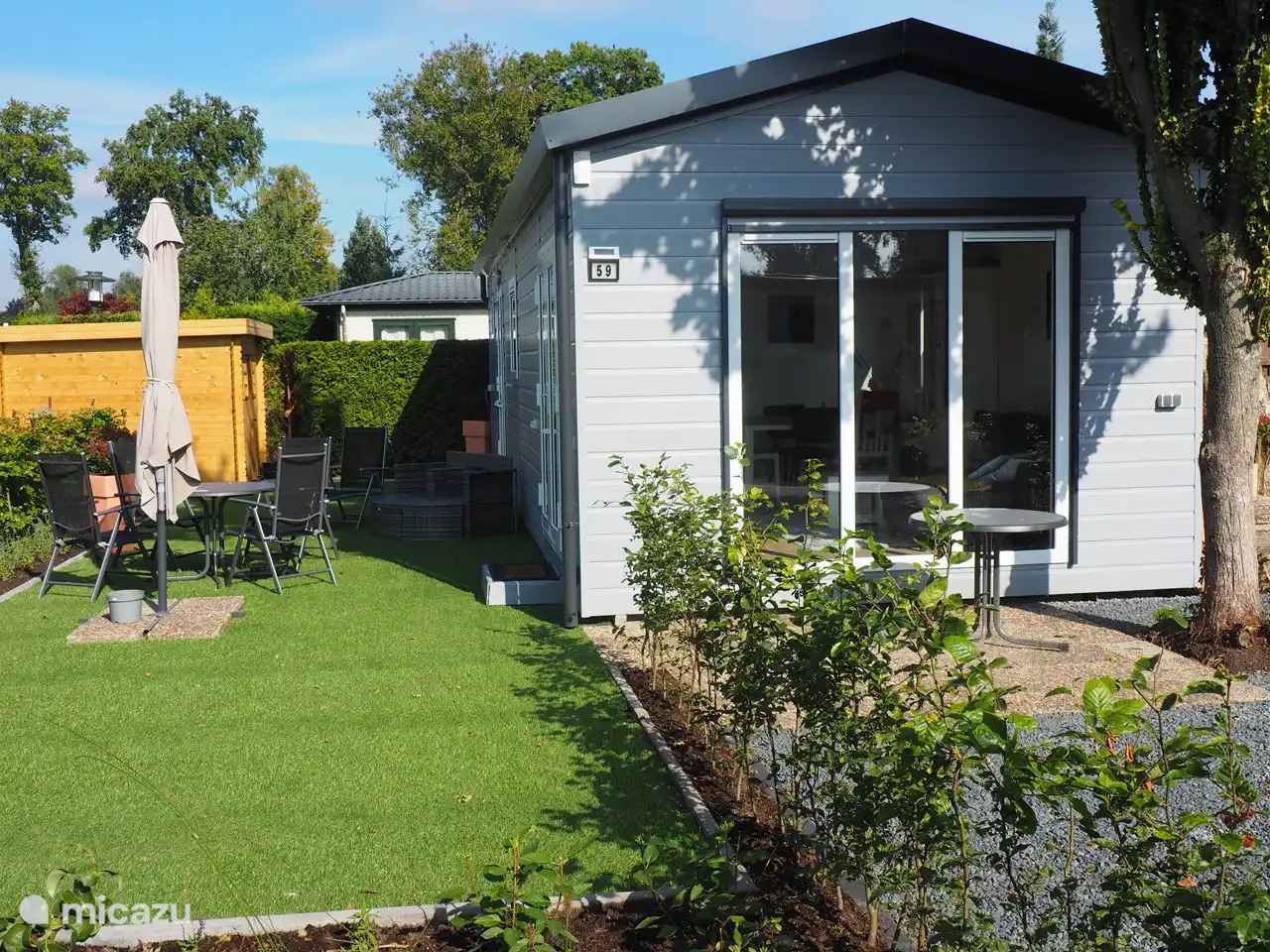 Die nach Süden ausgerichtete Front hat einen elektrischen Sichtschutz, obwohl der Baum morgens auch Schatten spendet.