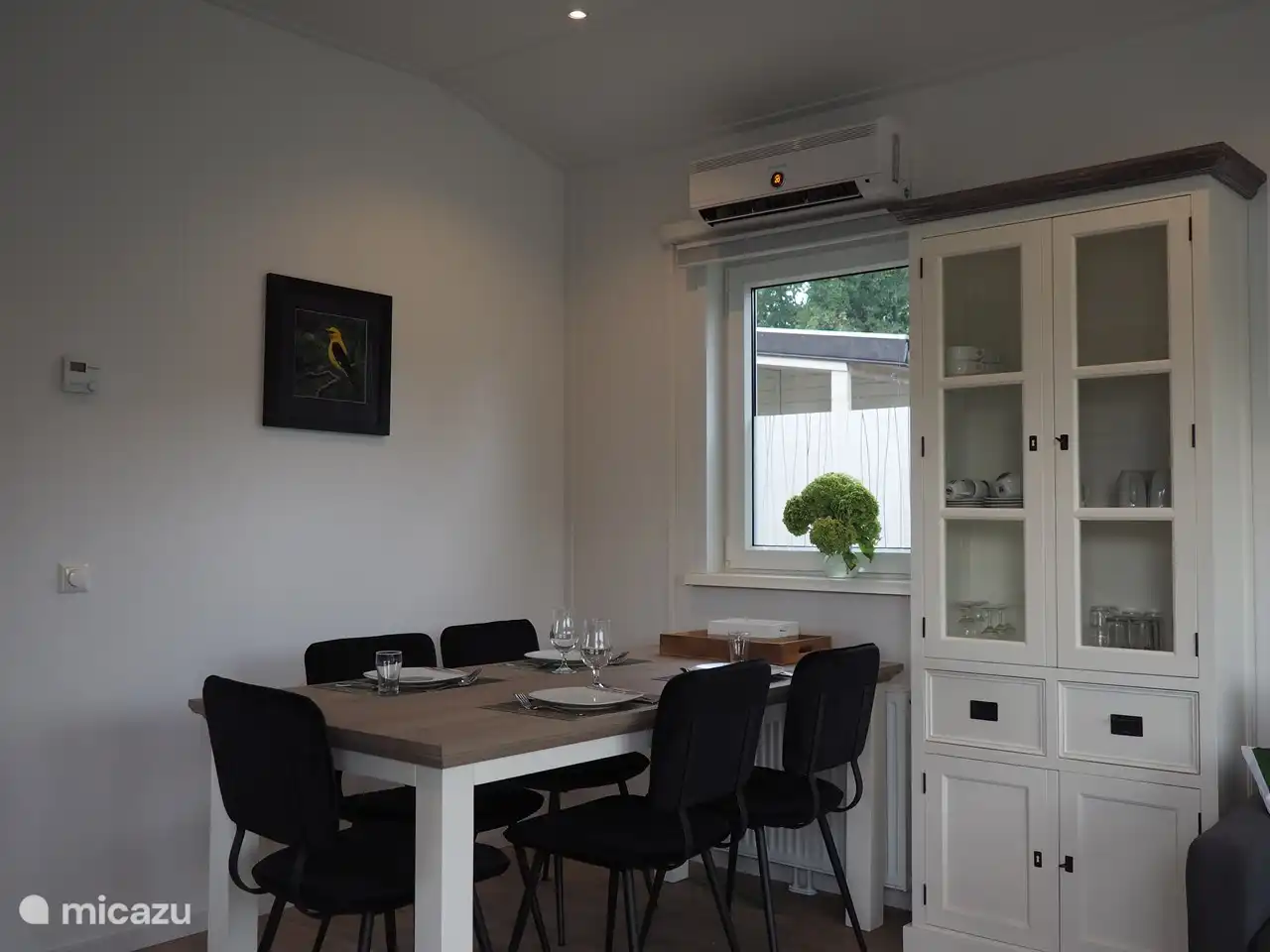 Der Essbereich vor dem Seitenfenster mit einem Sideboard für das Geschirr