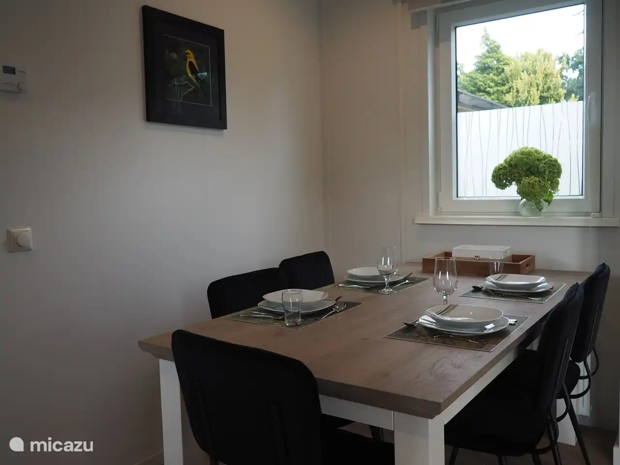 Geräumiger Esstisch mit bequemen Stühlen, auch für einen zusätzlichen Gast.