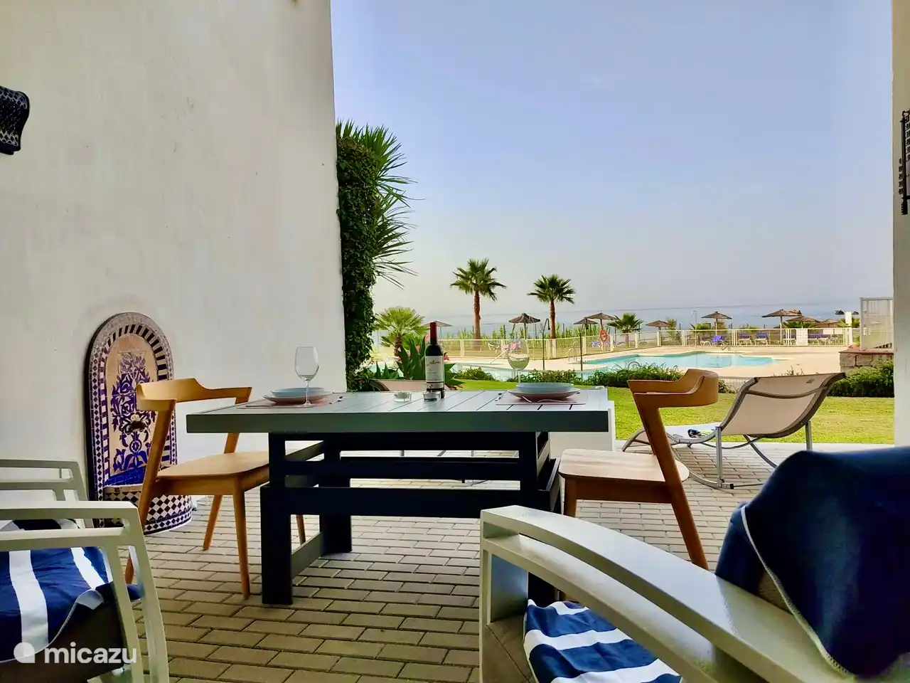 Terrasse mit Tisch, der niedrig (Salontisch) und hoch (Esstisch) aufgestellt werden kann.