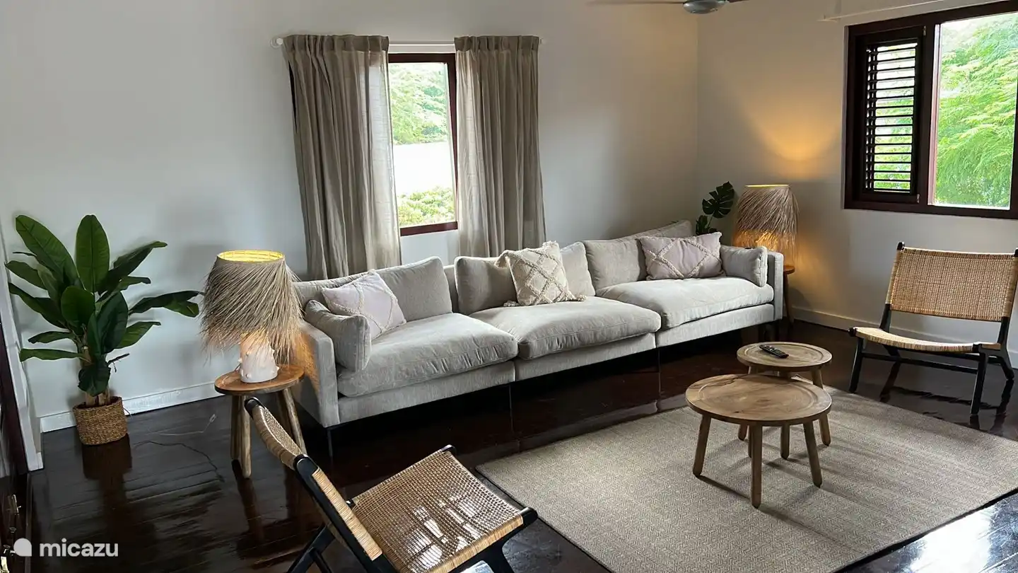 Woonkamer met openslaande deuren naar nog een terras aan de achterkant van de woning.