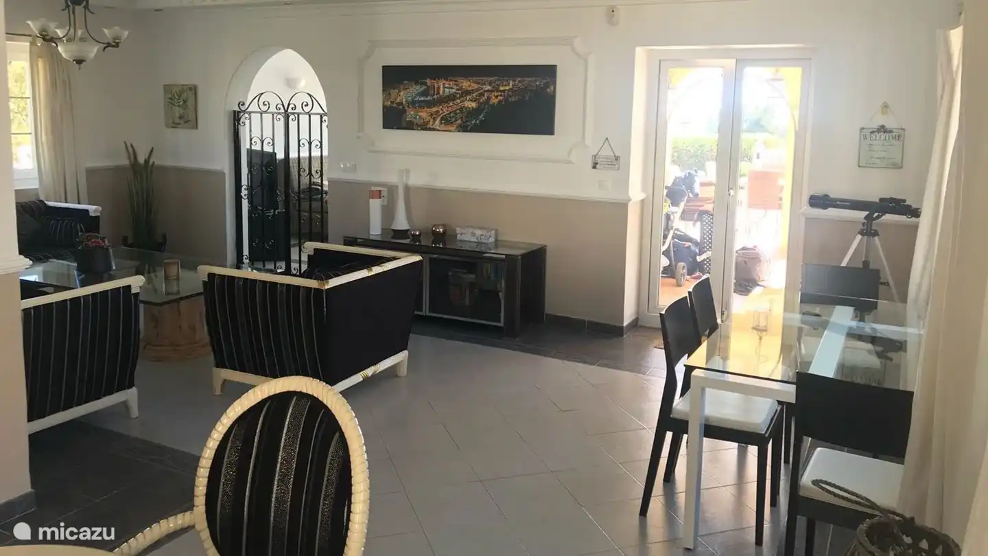 Links die Sitzecke mit Durchgang zum Fernsehraum und rechts die Tür zur Terrasse und zum Swimmingpool.