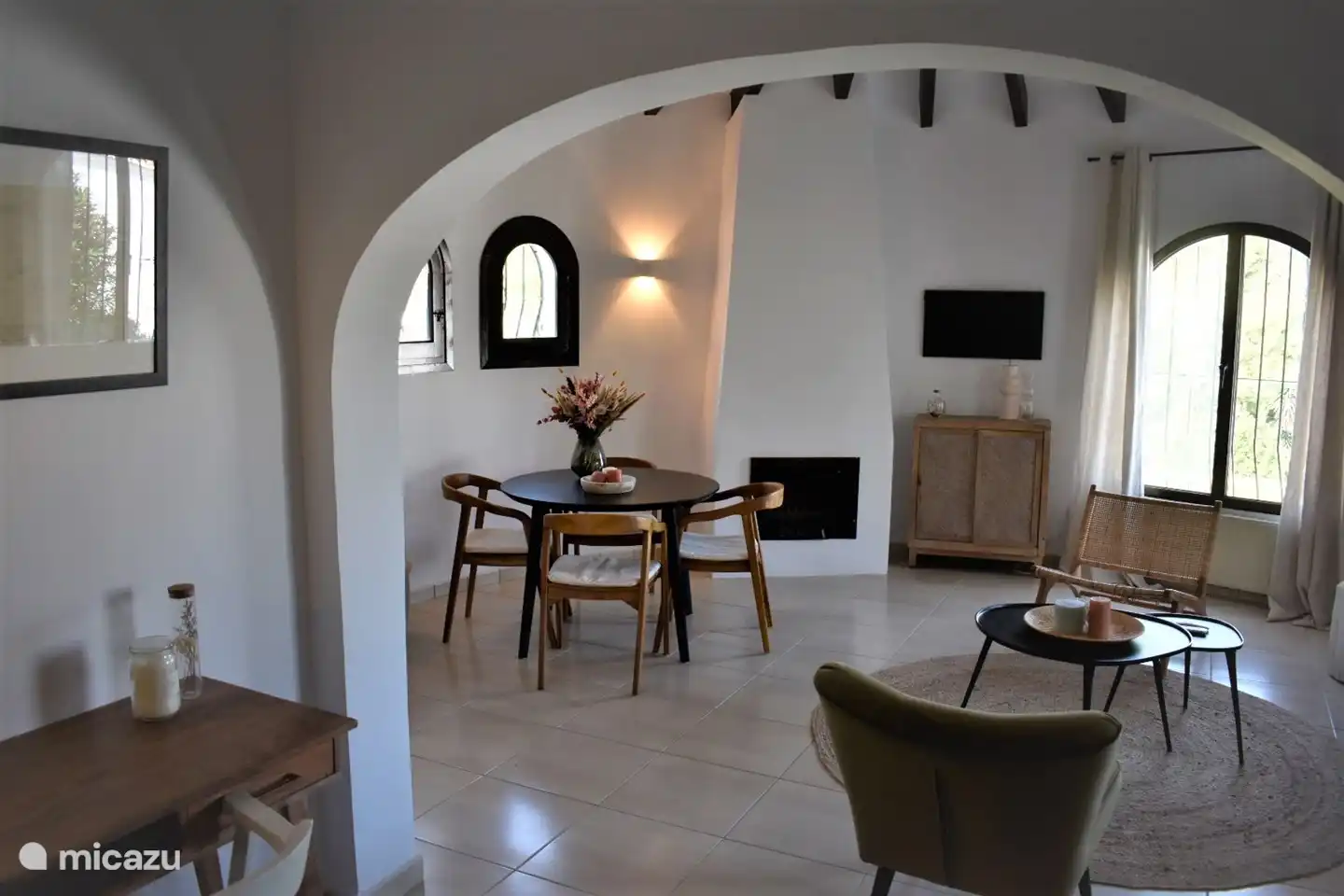 Gemütliches Wohnzimmer mit hoher Decke und Kamin.