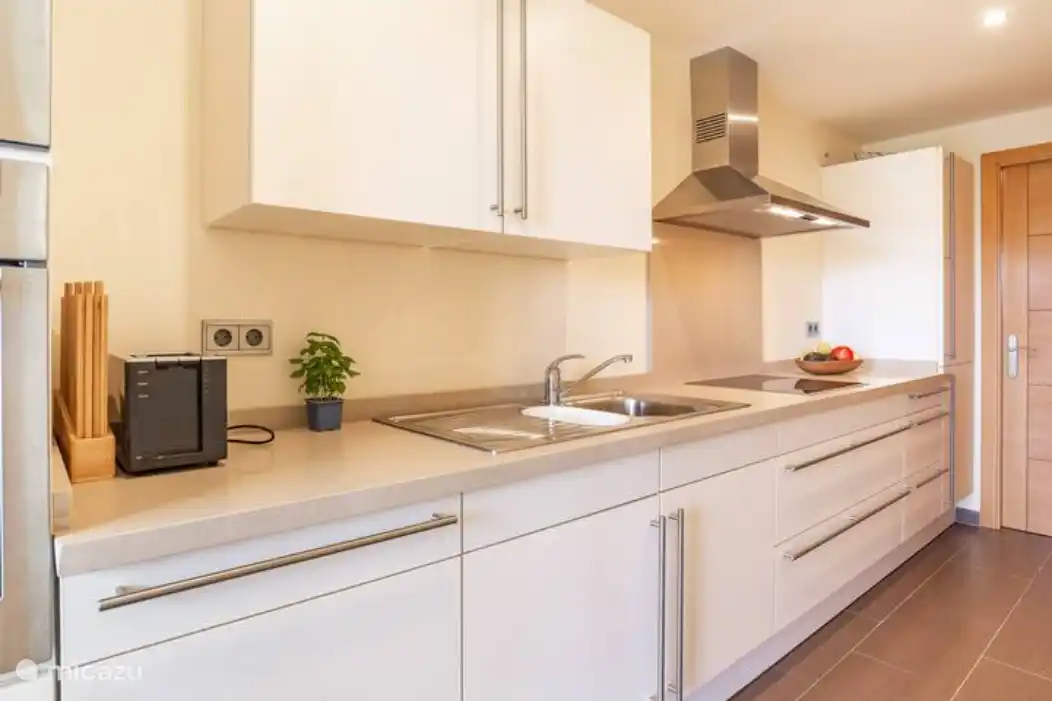 La maison dispose d'une cuisine semi-ouverte entièrement équipée avec plaque vitrocéramique, four, micro-ondes, lave-vaisselle et réfrigérateur/congélateur.