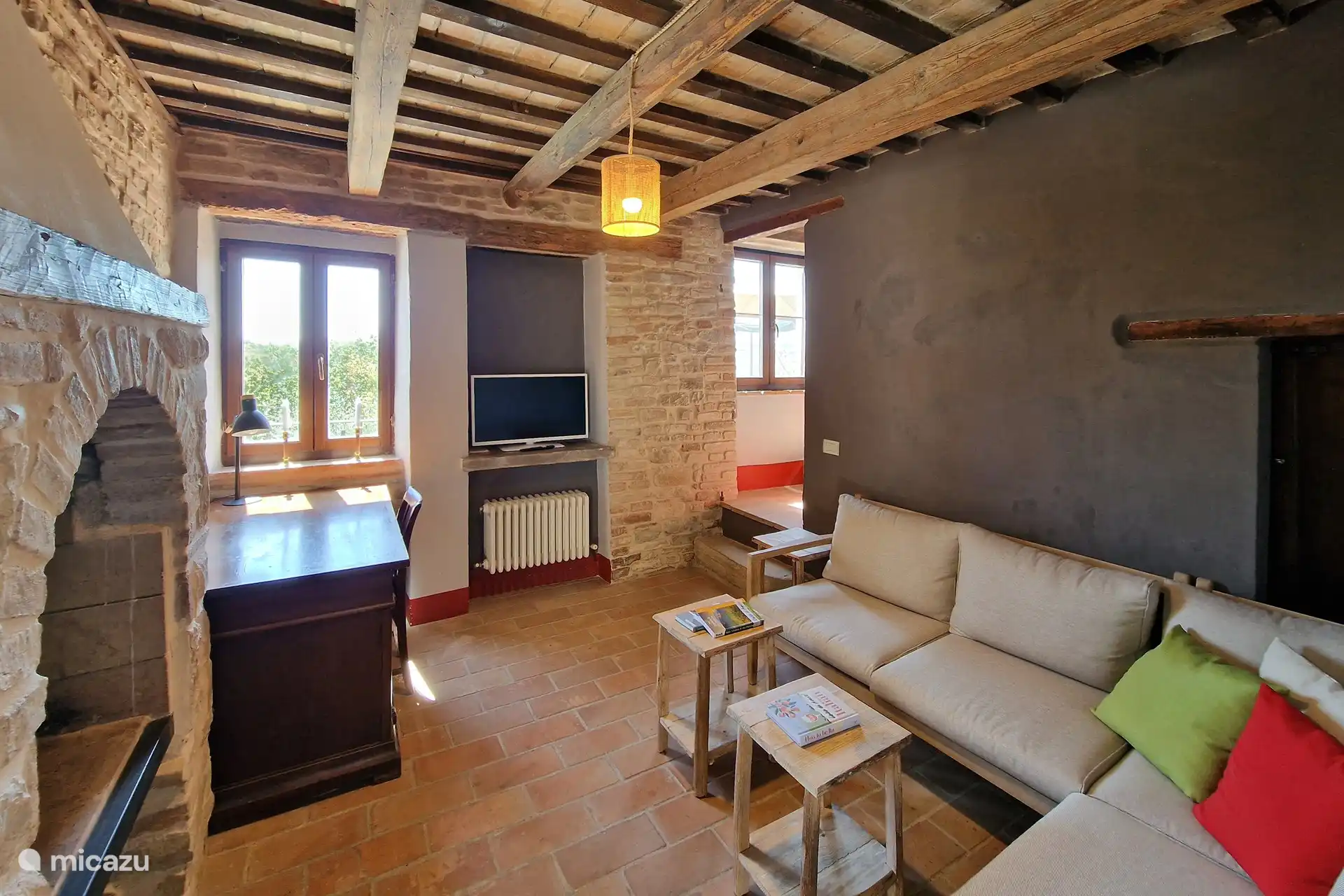 Auf diesem Foto sehen Sie ein schönes langes Sofa, auf dem Sie sitzen und ein Buch lesen, Ihren Lieblingsfilm ansehen oder den Kamin genießen können. Oder Sie arbeiten im Urlaub am Schreibtisch.