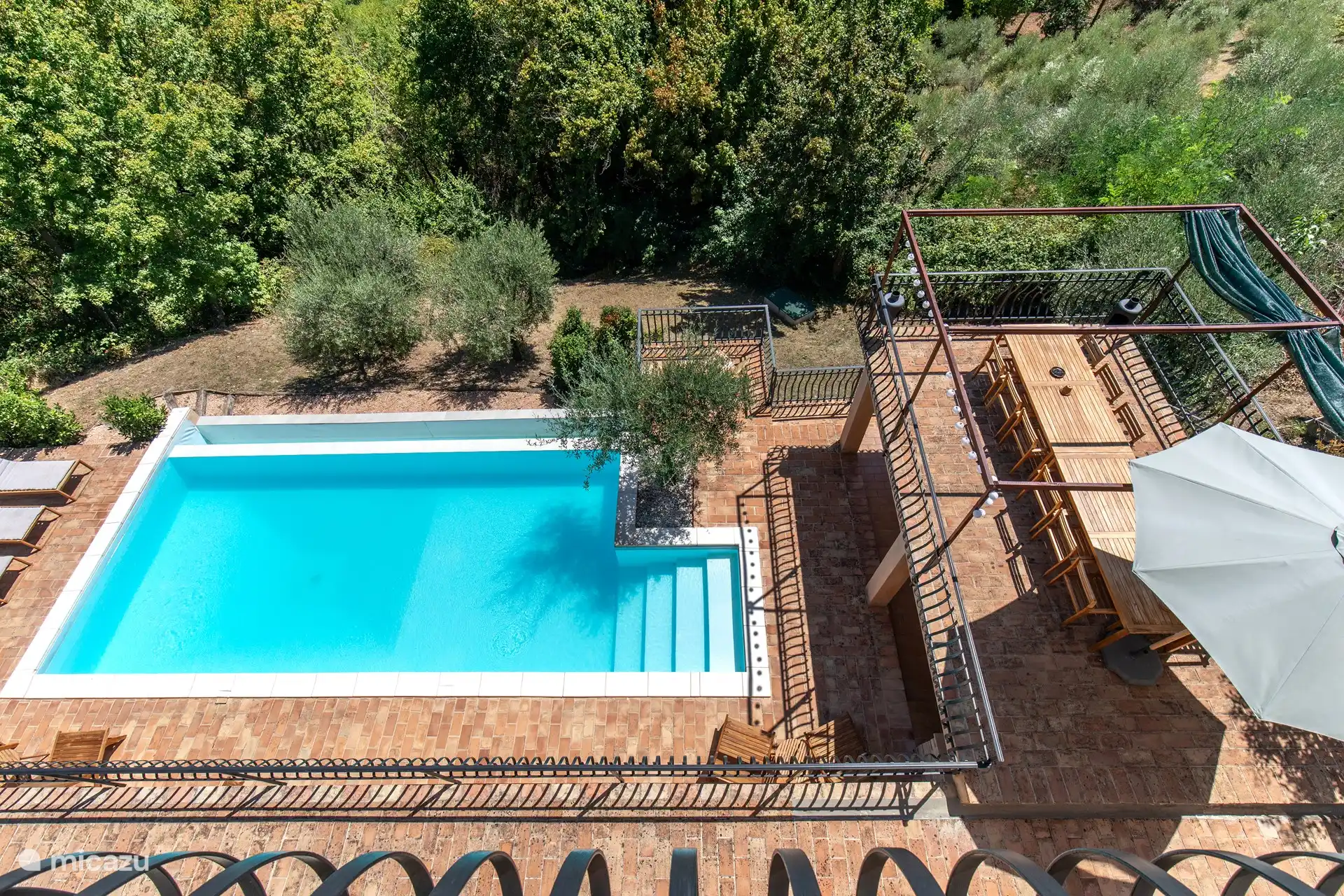 Auf diesem Foto können Sie den Pool aus der Ferne sehen und den Esstisch im Freien, an dem Sie die Aussicht, die Sonne und den Pool genießen können. Es gibt auch einen Sonnenschirm am Haus, weil die Sonne zu stark ist.