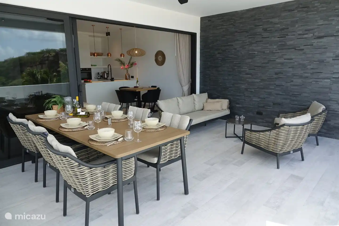 Terrasse avec table à manger, chaises et canapé lounge.