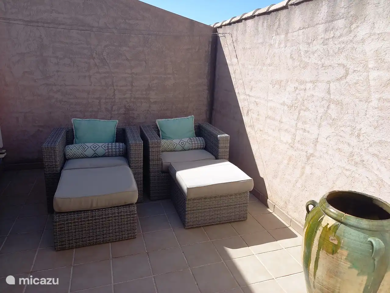 Patio au premier étage avec deux chaises longues pour une assise détendue.