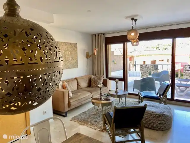 Coin salon spacieux avec 6 places assises, une TV 140cm 4k et une chaîne hi-fi Bose.