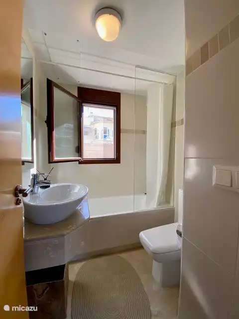 Deuxième salle de bain avec baignoire et lavabo.