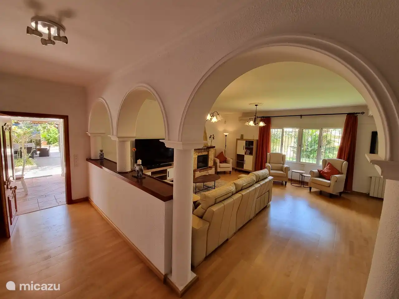 Ein geräumiges Wohnzimmer mit einer gemütlichen Sitzecke und einem großen Fernseher mit Chromecast, Internetverbindung und einem guten Soundsystem.