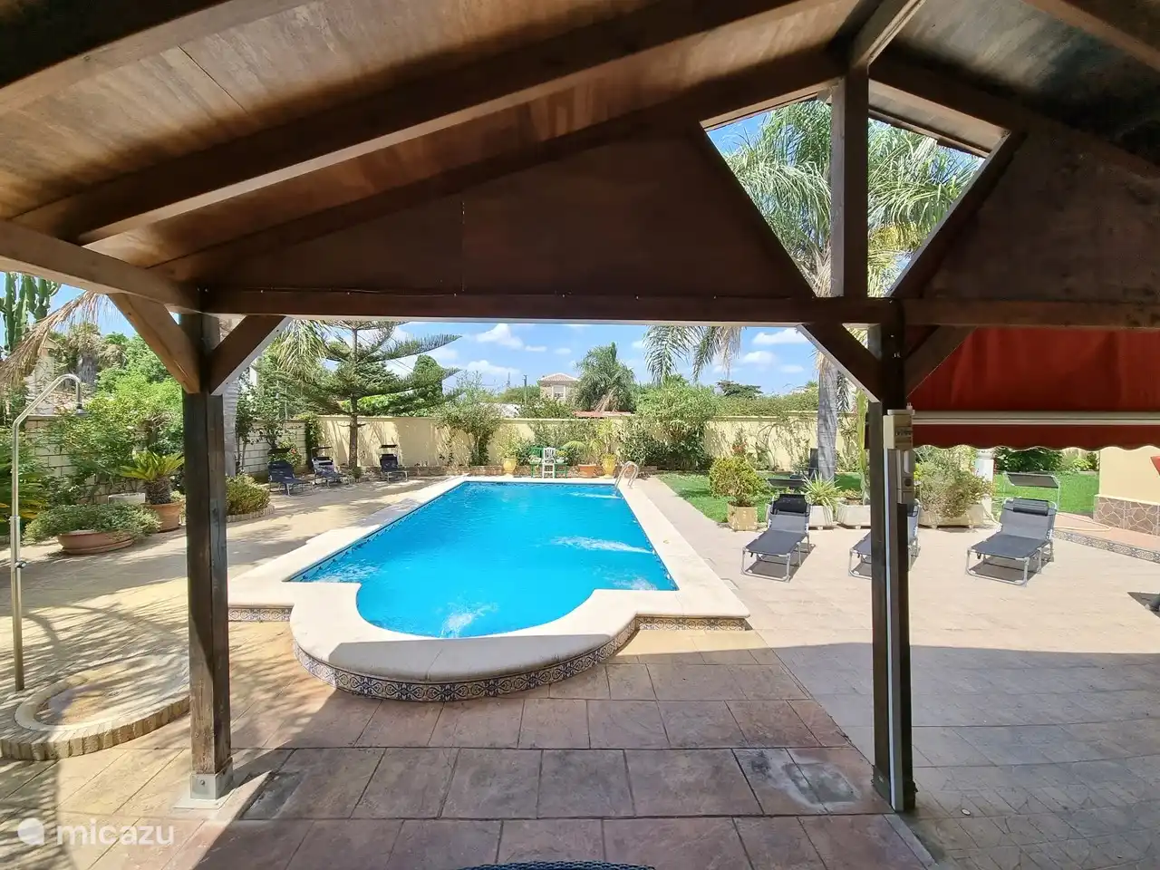 Es gibt mehrere Sonnenliegen im Garten.