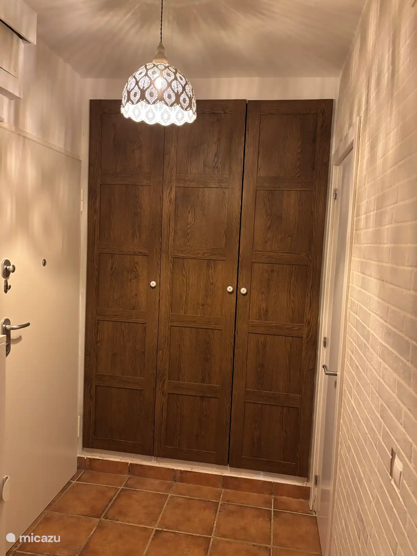 Bij binnenkomst staat deze kast links met daarin: wasmachine, stoeltjes en parasol voor op het strand, 2 strandtassen en een kleine koelbox. 