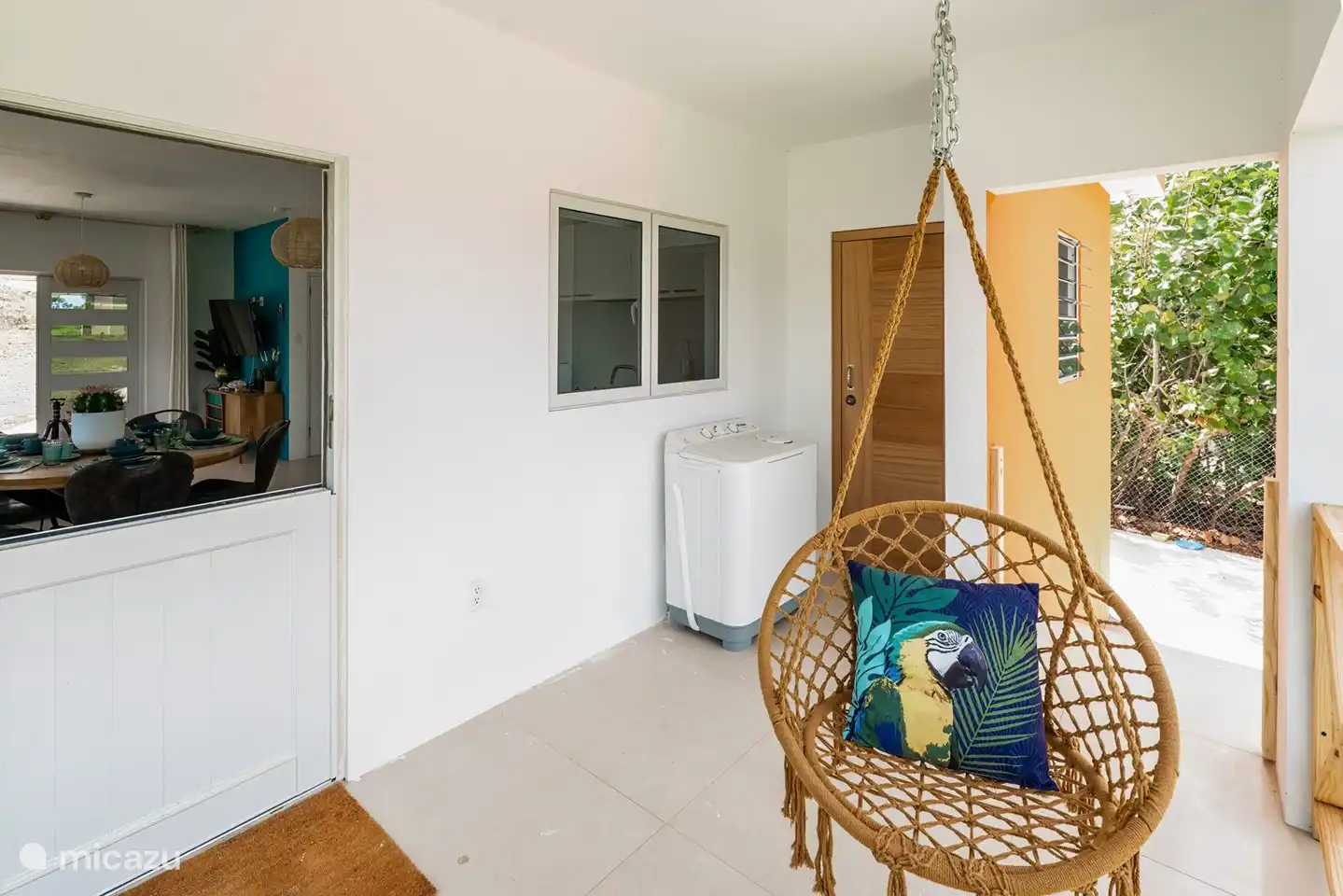 Back porch with hanging chairs and washing machine.