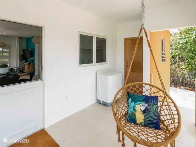 apartamento en Curazao, Banda Arriba (este), Cas Grandi – Apartamento de vacaciones Coral Cactus Porche trasero con sillas colgantes y lavadora.
