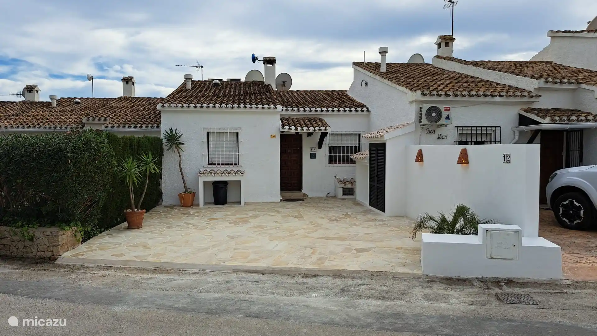 vor Haus und Garten mit Parkplatz