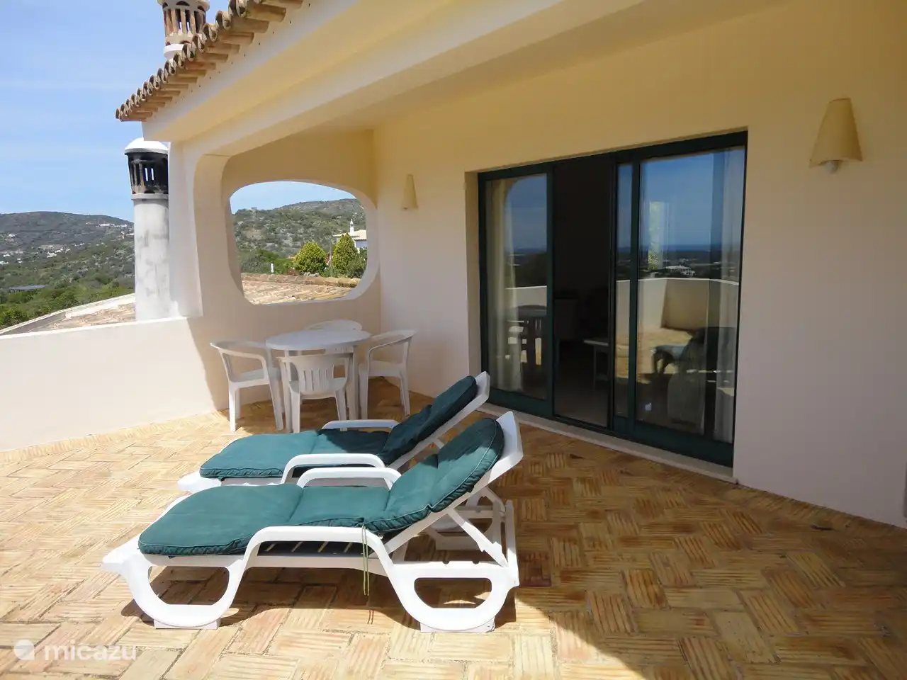 Balcón con tumbonas