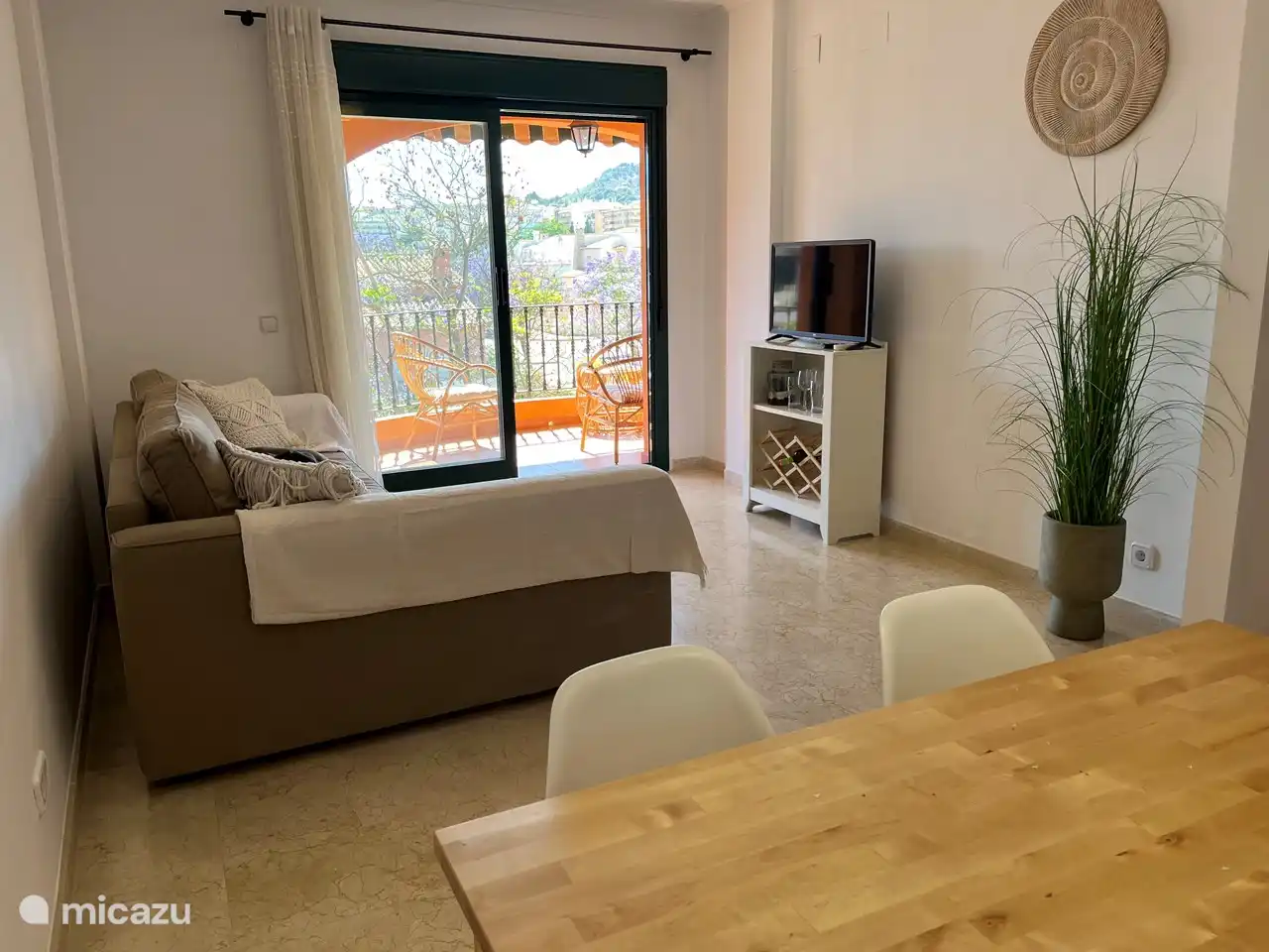 Salon avec grand canapé, TV avec Google Chromecast, coin repas, climatisation, etc.