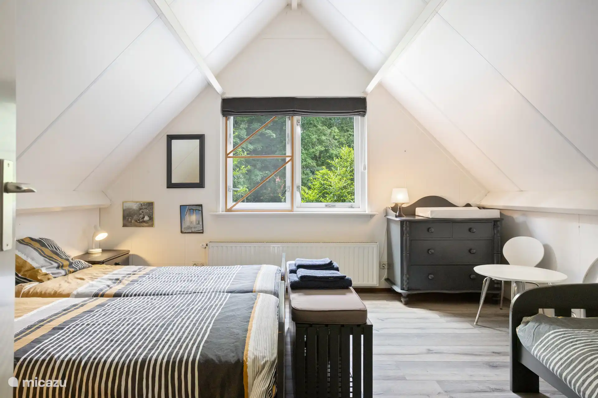 Die Treppe führt Sie zum Treppenabsatz, wo sich 2 Schlafzimmer befinden. An der Vorderseite befindet sich ein Schlafzimmer mit 3 Einzelbetten und einem Kinderbett und Wickeltisch.