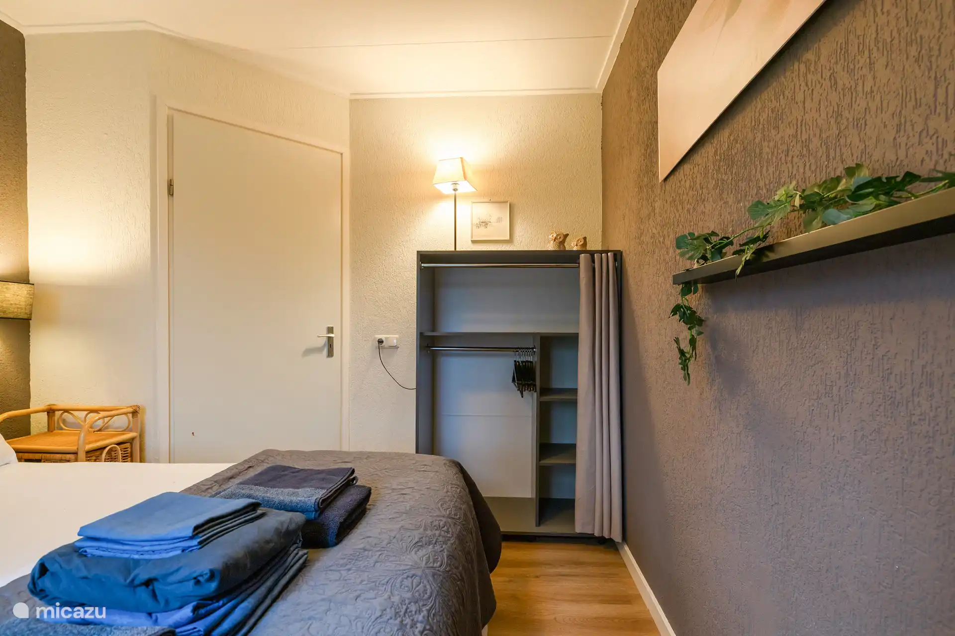 El dormitorio de abajo tiene una cama de somier y un armario sencillo.