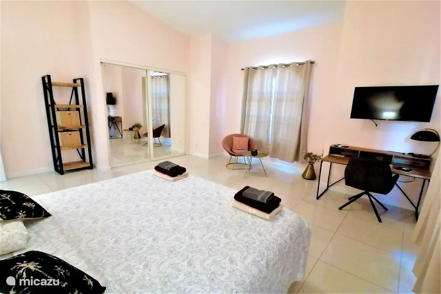 The pink bedroom with large mirror closet and king bed