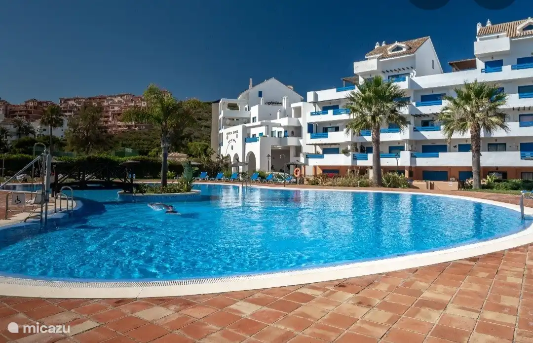 Großer Swimmingpool mit Liegestühlen und Rettungsschwimmer