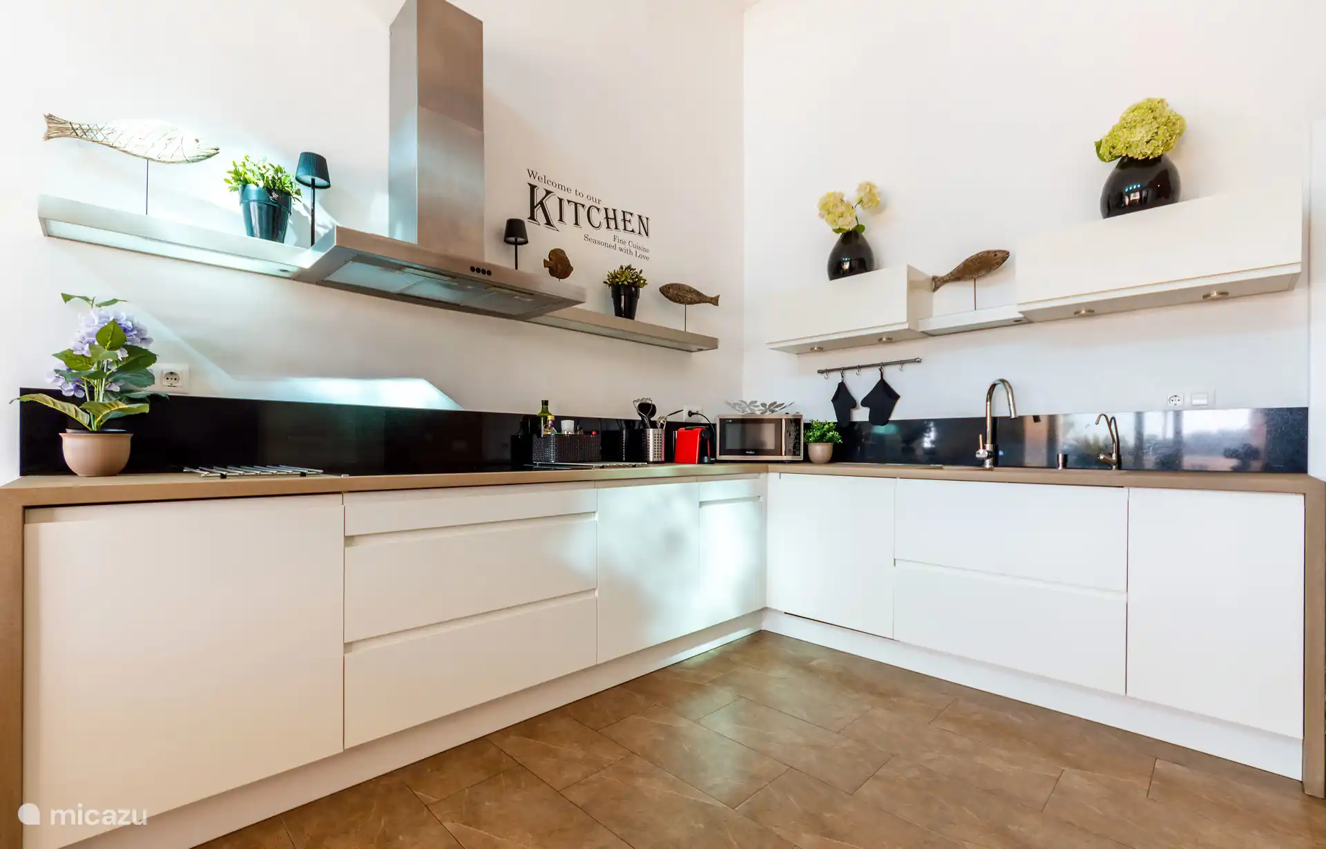 Ruime keuken met oven, magnetron en afwasmachine.