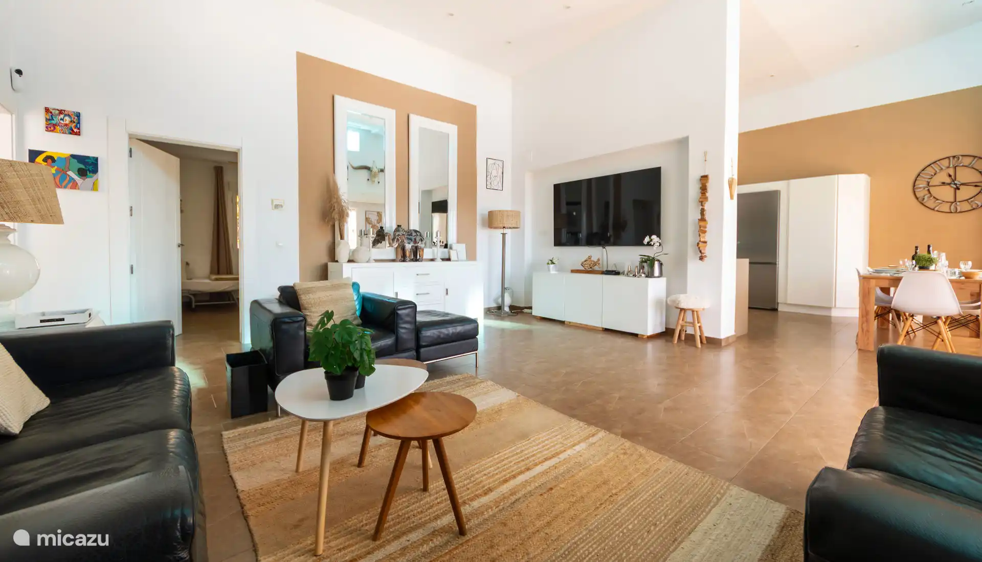 Woonkamer met internationale TV naast de keuken