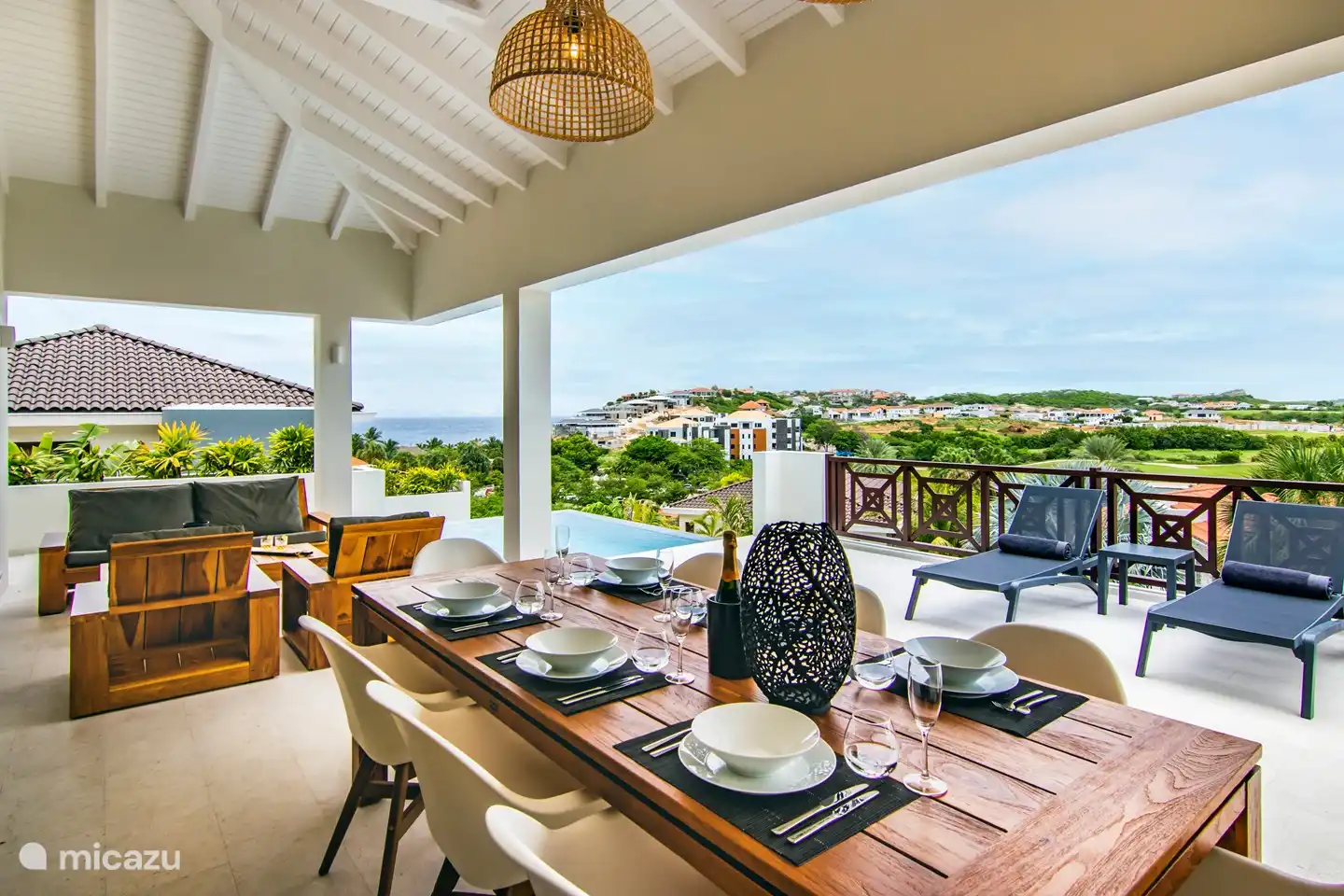 überdachte Terrasse mit großem Esstisch und Lounge-Set