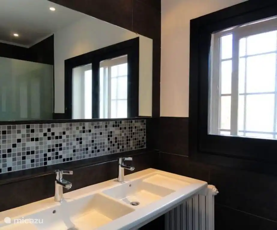 Badezimmer mit Dusche, WC und Doppelwaschbecken im Obergeschoss