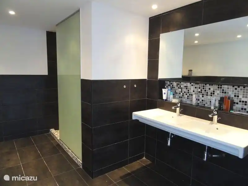 Badezimmer mit Dusche, Badewanne, WC und Doppelwaschbecken. Das en-suite Badezimmer gehört zum Schlafzimmer im Untergeschoss