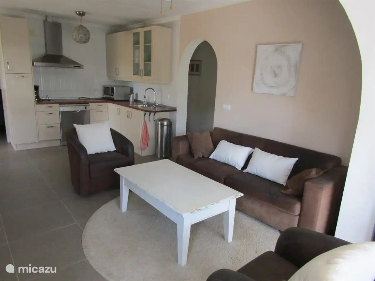 Wohnzimmer mit großem Sofa und zwei Sesseln. In der offenen Küche finden Sie alles, was Sie brauchen. (Erdgeschoss)