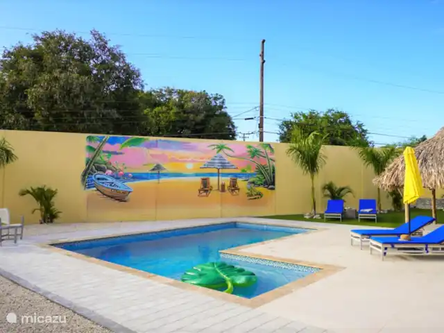 Villa Leguano Julianadorp Curaçao huren in Curaçao, Curacao-Midden, Julianadorp - vakantiehuis Om buiten te relaxen kunt u gebruik maken van het zwembad met relax pooldeck en de palapa, heerlijke ligbedden, zitjes en loungeset. Binnen heb je een volledig ingerichte keuken met ruime woonkamer. 
De muurschildering is gemaakt door de lokale kunstenaar Wendel.