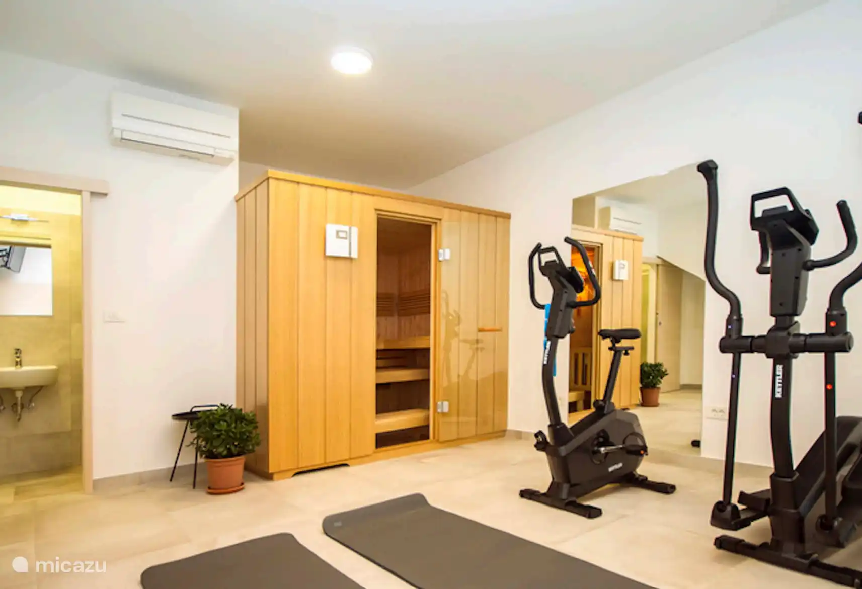 Sala de fitness en el sótano con ducha y WC. 