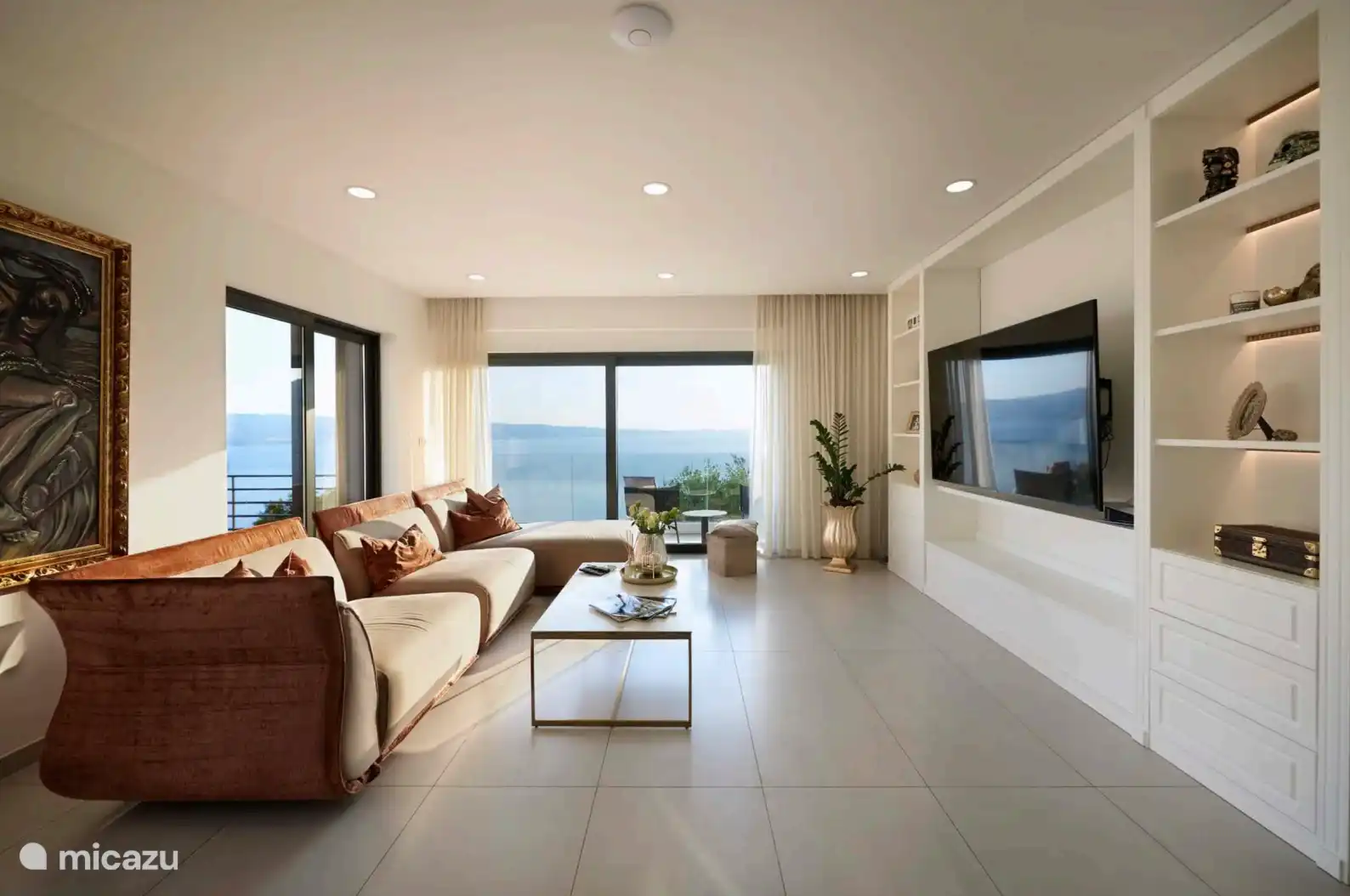 Acogedora sala de estar con un gran sofá cómodo y puertas que dan al balcón. 