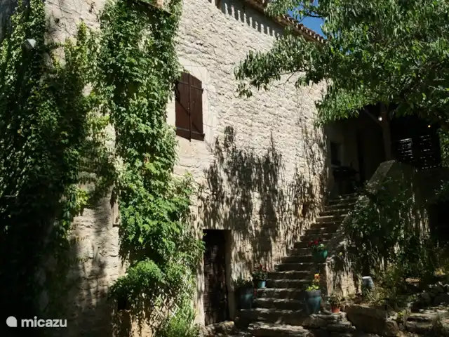 L’ancienne ferme de Goth | France, Lot, Serignac - maison de vacances La vue latérale de la maison, avec le grand escalier en pierre menant à la porte d'entrée et à la terrasse.