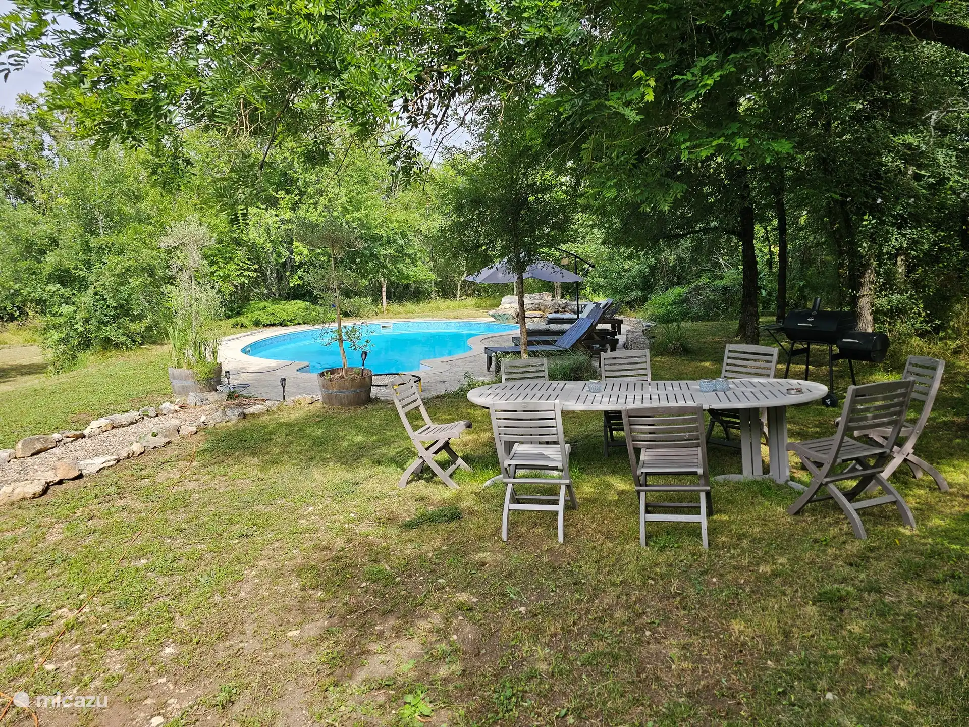 Piscina con grandes muebles de jardín