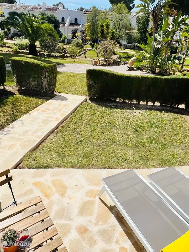 This photo was taken from the terrace. You see the private garden with 2 sunbeds & an extra bistrot table with 2 chairs 
Via the path you will enter the communal garden.