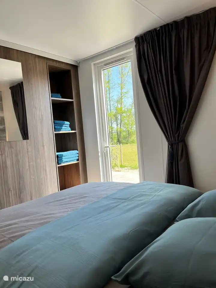 Schlafzimmer mit Doppelbett und eigenem Duschbad mit WC. Öffnende Gartentür