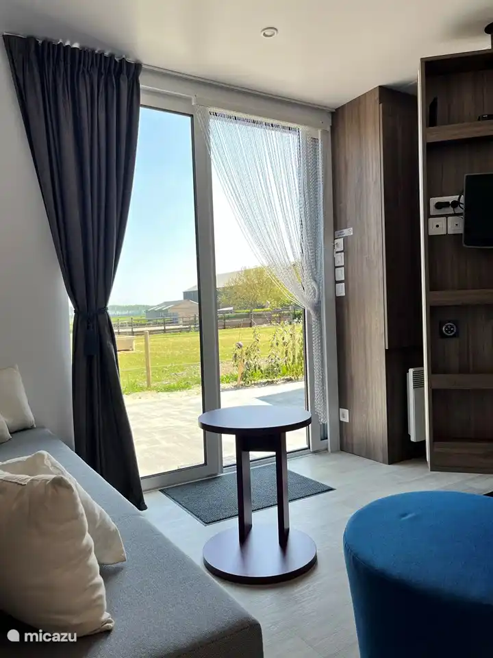 Blick von der Couch auf die Wiese und den Polder