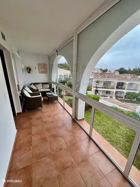 hermosa terraza acristalada con ventanas corredizas y vista al mar, hermosa terraza, césped y áreas para tomar el sol.