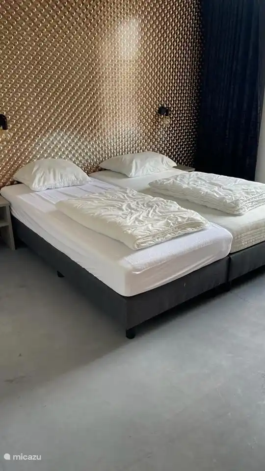 Schlafzimmer. Alle Boxspringbetten haben Einzelbettdecken und können problemlos zusammen- oder auseinandergelegt werden. Optional kann Bettwäsche gemietet werden.