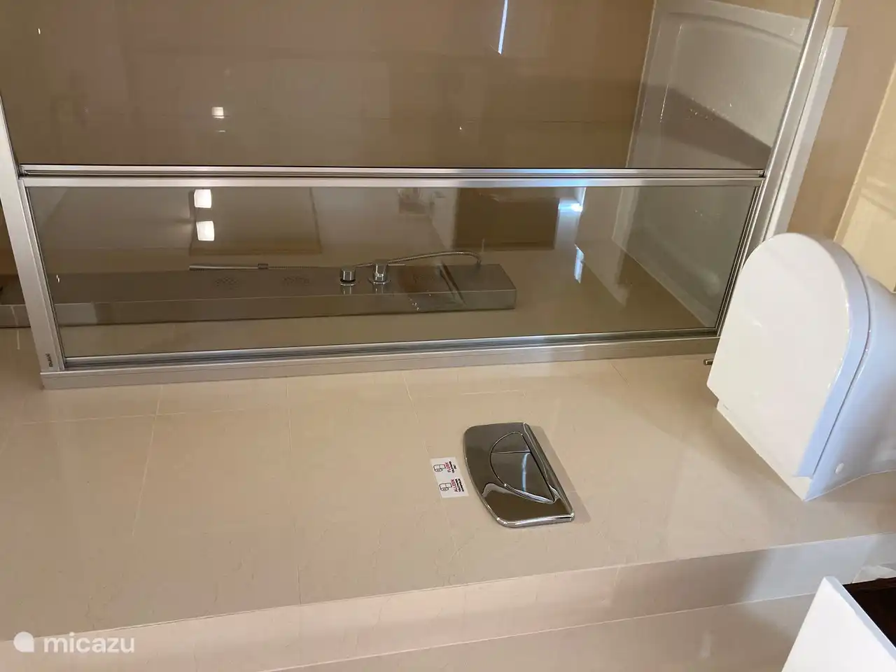 De badkamer op de begane grond bevat een wastafelmeubel, een WC en een douche.