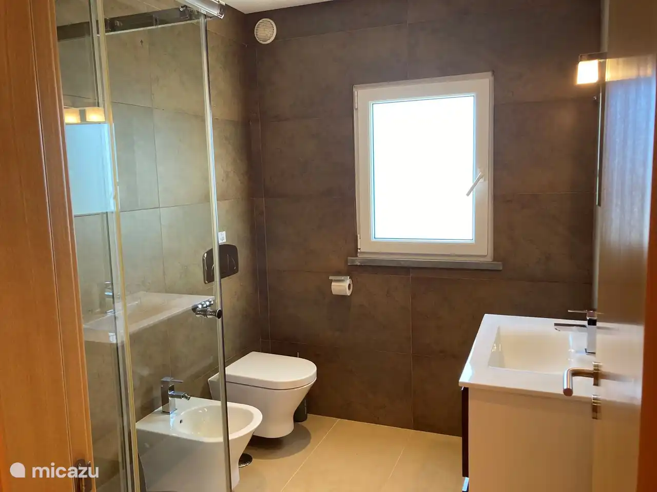 De badkamer die onderdeel uitmaakt van de hoofdslaapkamer bevat een douche, bidet, WC en wastafelmeubel.