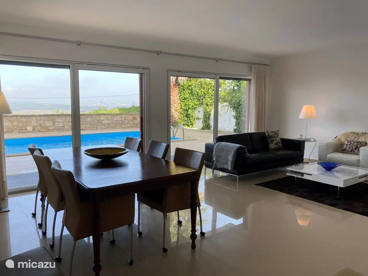 De woonkamer is op het noordwesten gelegen en kijkt uit op het terras en zwembad. 